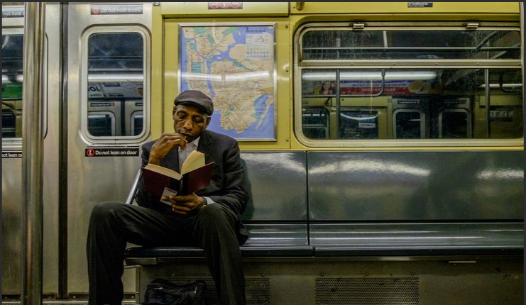 A Person Reading a Book in a Subway